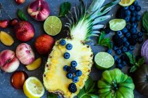 Arco-íris de frutas, legumes e ervas em uma superfície azul — Fotografia de Stock