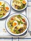 Plato de arroz con pescado y huevos cocidos en tazones - foto de stock