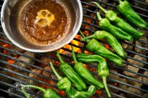 Green chilli peppers on a grill — Stock Photo