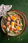 Ensalada con habas, pepino, aceitunas, salmón, huevo y aderezo de yogur griego - foto de stock