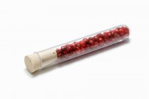 Red peppercorns in a test tube — Stock Photo