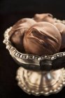 Schokoladenkonfekt mit Macadamia-Nüssen in einer silbernen Schüssel (Nahaufnahme) — Stockfoto