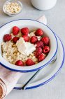 Oatmeal with mascarpone cheese, raspberry, pine nuts and honey — Stock Photo