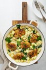 Roasted chicken thighs with gnocci and spinach — Stock Photo