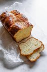 Delicioso pão caseiro fresco no fundo de madeira branca — Fotografia de Stock
