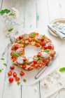 Profiterole wreath with whipped cream and strawberries with fresh mint — Stock Photo