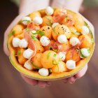 Melonensalat mit Mozzarella und Proscuitto in einer ausgehöhlten Melone — Stockfoto