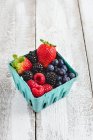 Різні свіжі ягоди в картонній коробці — стокове фото
