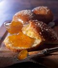 Brioche pastry sliced open with apricot jam and knife — Stock Photo
