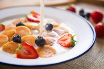 Minipanquecas de cereais em uma tigela com leite e frutas — Fotografia de Stock