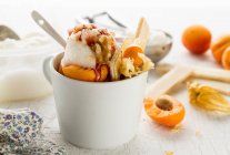 Vanilla ice cream with apricots, nuts and jam — Stock Photo