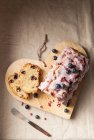 A sliced blueberry loaf cake with icing and dried rose petals — Stock Photo