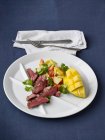 Grilled entrecote with a salad of papaya, mango, cucumber, tomatoes and coriander green — Stock Photo