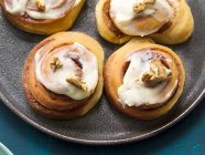 Cinnamon Rolls: cinnamon rolls topped with fresh cheese and walnuts — Stock Photo