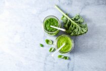 An apple and spinach smoothie and an apple and kale smoothie with basil — Stock Photo