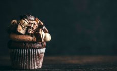 Um cupcake de chocolate com doces no topo para uma festa — Fotografia de Stock