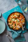 Паста Орзо, приготовленная в томатном соусе с королевскими креветками, овощами и сыром фета — стоковое фото
