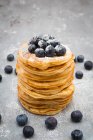 A stack of pancakes with blueberries and icing sugar — Stock Photo