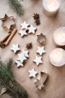 Cinnamon stars next to burning candles and fir tree branches — Stock Photo