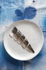 A raw mackerel cut into pieces on a plate (top view) — Stock Photo