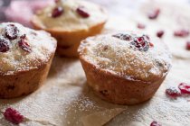 Muffins de cranberry recém-assados em pergaminho com cobertura de açúcar — Fotografia de Stock