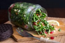 Tabuleiro de painço em um frasco de vidro com sementes de romã, salsa e hortelã — Fotografia de Stock