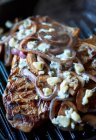 Bistecca di T-bone con cipolle e formaggio azzurro su una griglia — Foto stock