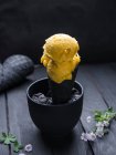 Sorbet végétalien à la mangue dans un cône de gaufre noire — Photo de stock