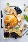 Baked brie wrapped in puff pastry with mushrooms with bread and cracker on a board — Stock Photo