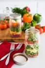 Шаруватий салат у склянці зі шпинатом, квасолею, сиром та яйцем — стокове фото