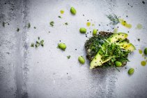 Fresh slices of avaocado on seeded bread with avaocado oil, endemame beans and micro greens — Stock Photo