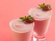 Frullati di yogurt alla fragola con bacche fresche nei bicchieri — Foto stock
