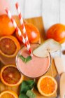 A blood orange smoothie with a straw in a glass — Stock Photo