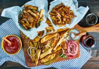 Ali di pollo alla griglia con ketchup e salsa su fondo di legno — Foto stock