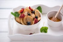 Vegane Mini-Pfannkuchenschale mit Beeren, Zuckersirup und Schokolade — Stockfoto