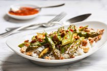 Espargos verdes fritos em molho doce e picante com caju em basmati e arroz selvagem — Fotografia de Stock