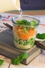 Hacer sopa de fideos asiáticos en un vaso: Añadir agua caliente y dejar cocer - foto de stock