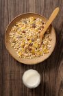 Oatmeal muesli in a wooden bowl with a glass of milk — Stock Photo