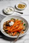 Im Ofen gebratene Karotten mit Couscous, Minze, Pistazien, Preiselbeeren und Limetten-Joghurt-Dip — Stockfoto