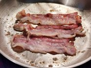 Bacon sendo frito em uma panela — Fotografia de Stock