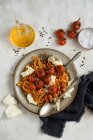 Pasta con tomates asados y mozzarella en placa metálica - foto de stock