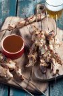 Pork skewers served with BBQ sauce and beer — Stock Photo