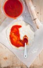 Salsa di pomodoro su pasta di pizza fuori stesa — Foto stock