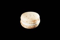 White and black macaroon isolated on a dark background. — Stock Photo