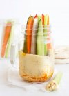 Bâtonnets de légumes dans un bocal en verre avec houmous — Photo de stock