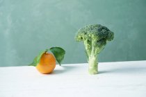 An orange and broccoli — Stock Photo