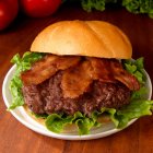 Close-up de delicioso hambúrguer com bacon e alface — Fotografia de Stock