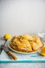 Une pile de panakes avec du caillé de citron et des tranches de citron frais — Photo de stock