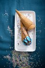 Blue vegan ice cream with chocolate sauce and sugar confetti in cones — Stock Photo