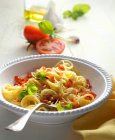 Pasta with tomato chunks and pine nuts — Stock Photo